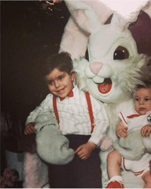Young Brendan sitting on the lap of an Easter Bunny mascot with another child.